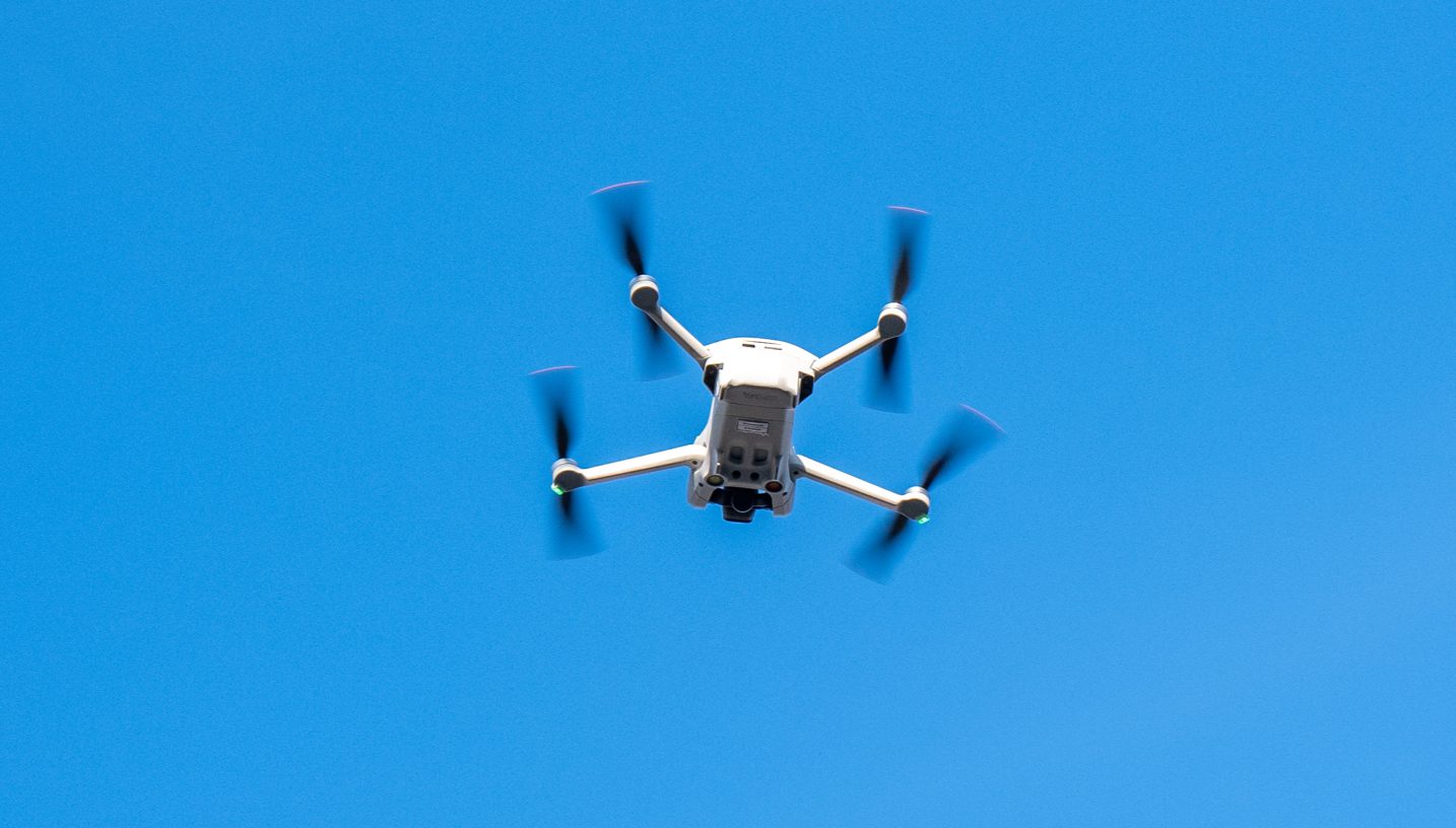 DJI Mini series cinematic drone in flight capturing high-stability aerial footage.